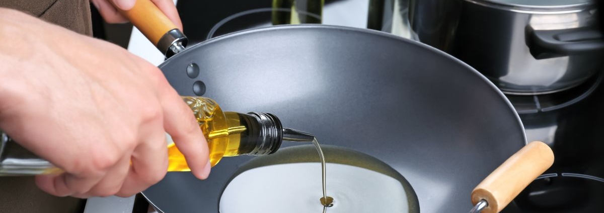 person pouring oil into a cooking wok - Anytime Olive Oil Products wholesale olive oil pour spouts
