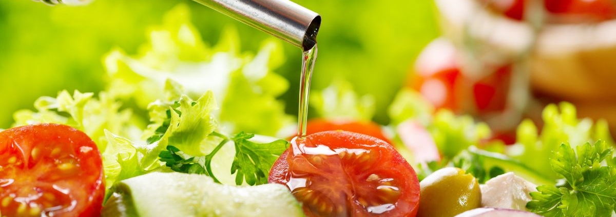 person pouring oil over tomatoes and lettuce - Anytime Olive Oil Products olive oil pour spouts