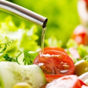 person pouring oil over tomatoes and lettuce - Anytime Olive Oil Products olive oil pour spouts