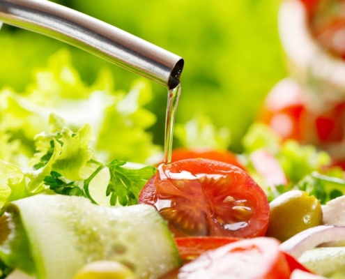 person pouring oil over tomatoes and lettuce - Anytime Olive Oil Products olive oil pour spouts