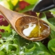 person pouring oil into a spoon over a salad - Anytime Olive Oil Products olive oil pour spouts