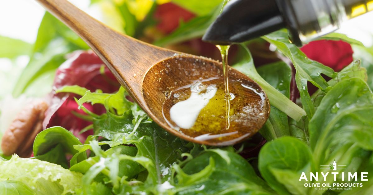 person pouring oil into a spoon over a salad - Anytime Olive Oil Products olive oil pour spouts
