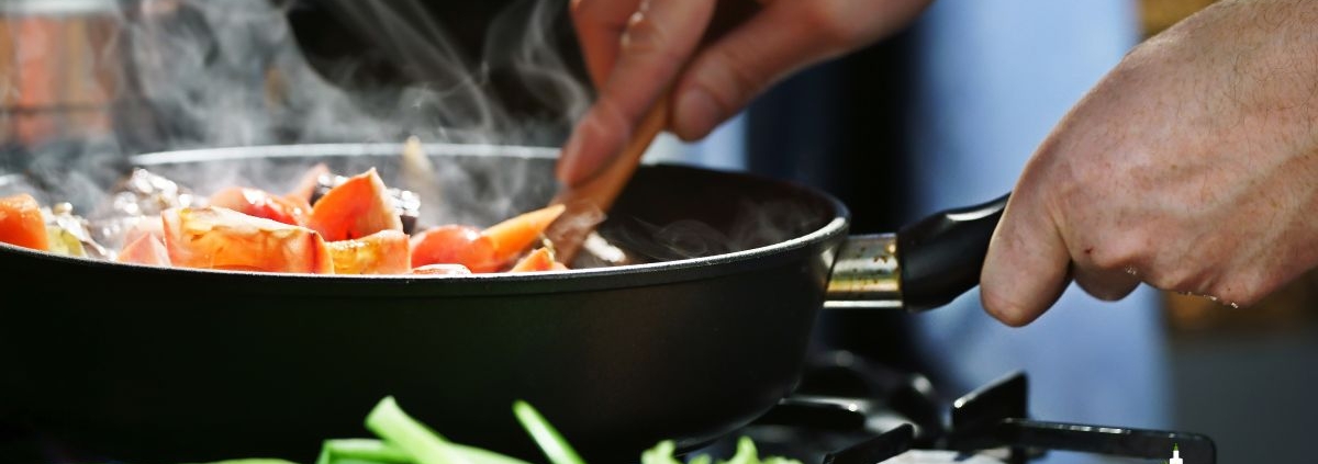 person stirring food in a fry pan - Anytime Olive Oil Products oil spout