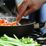 person stirring food in a fry pan - Anytime Olive Oil Products oil spout