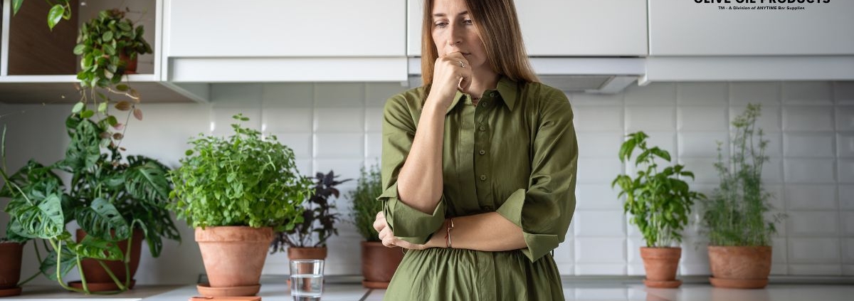 woman wearing green dress thinking in her kitchen - Olive Oil Pour Spouts wholesale olive oil pour spouts