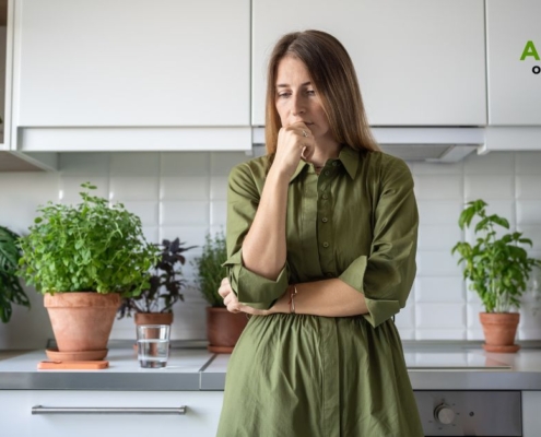 woman wearing green dress thinking in her kitchen - Olive Oil Pour Spouts wholesale olive oil pour spouts