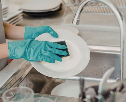 person washing dishes with a sponge - Olive Oil Pour Spouts Commercial-Grade Olive Oil Spouts