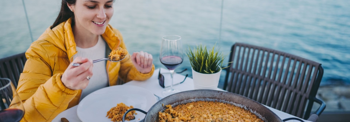 tourist woman eating a rice dish - Anytime Olive Oil Products wholesale olive oil pour spouts