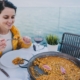 tourist woman eating a rice dish - Anytime Olive Oil Products wholesale olive oil pour spouts