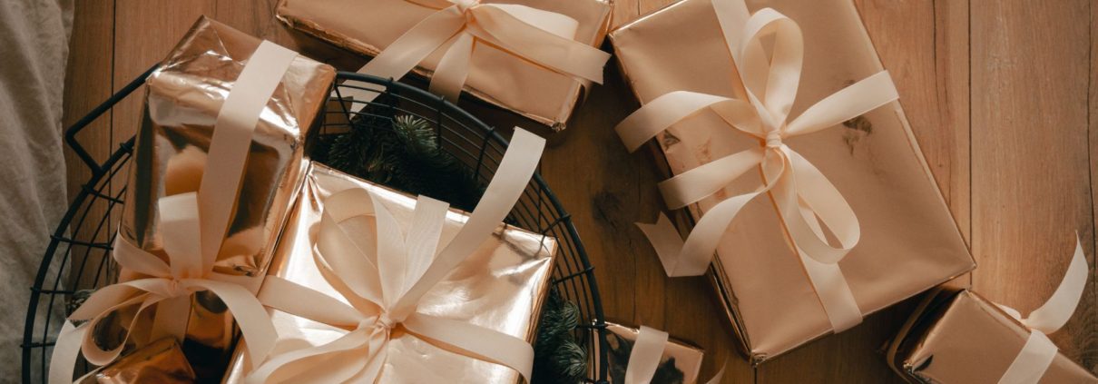 Wrapped wedding gifts on a wood table - Olive Oil Pour Spouts DIY gourmet wedding favors